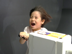 子どもが台風の風を体験できる実験装置を体験している写真