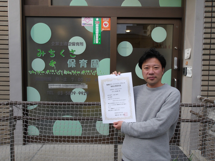 みちくさ保育園前で、園長が認定証を掲げている写真